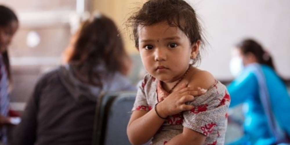 A young girl holding her arm that just received a vaccine