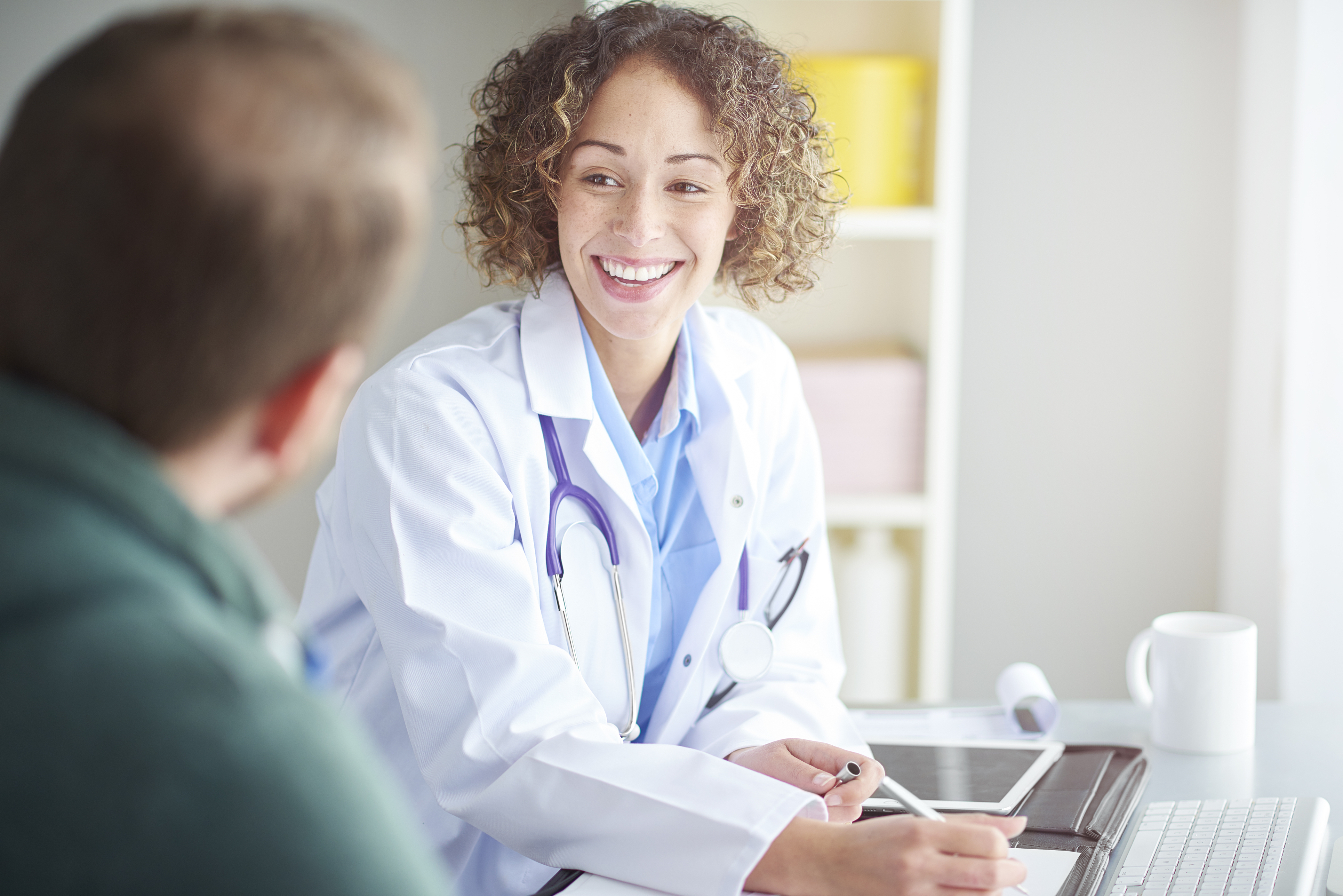 Young female medical professional talking to patient