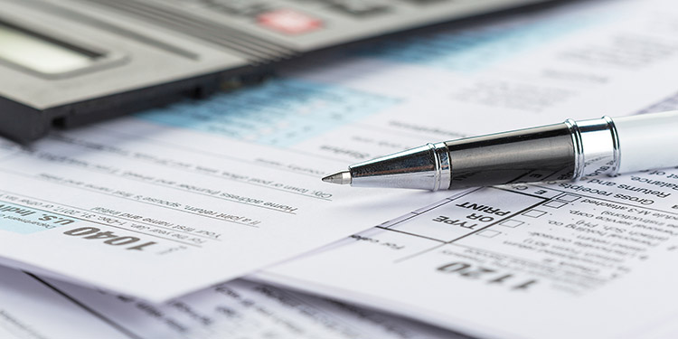 small calculator and tax forms on a desk
