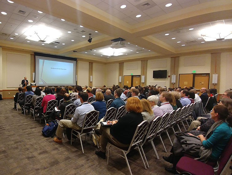 A group of people seated looking at a projector