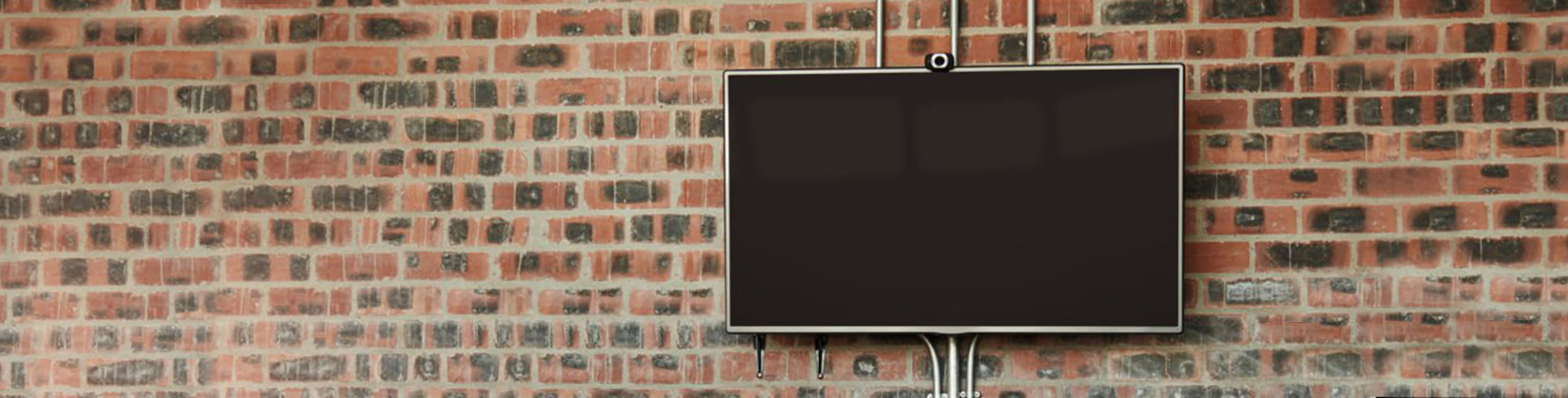 a screen hung from a brick wall, not in use