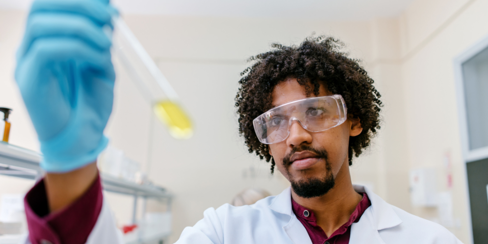 A man holds up a test tube in a lab