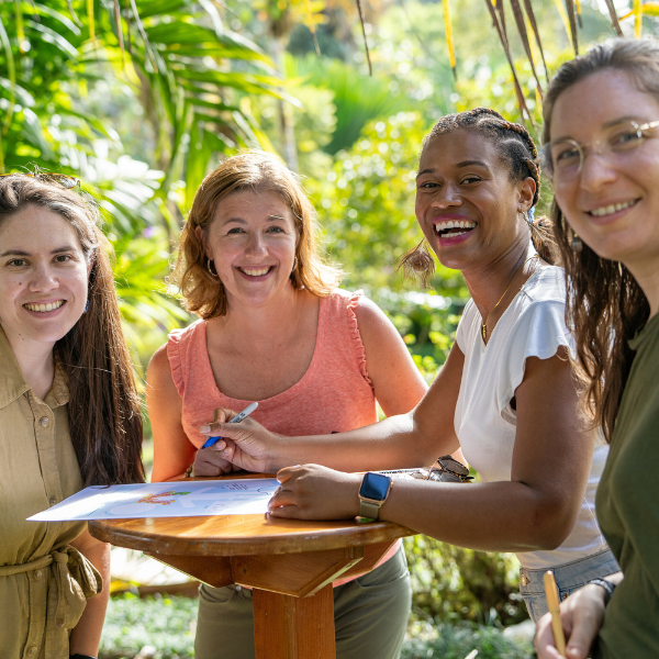 Four UMB faculty members work together at a standing table outside in Costa Rica