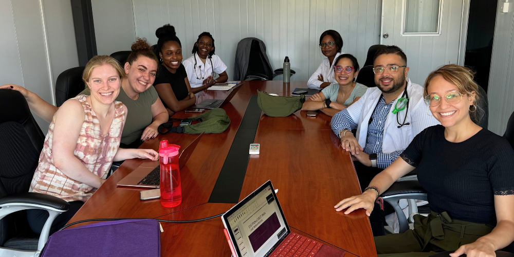 A group of students work around a table with laptops