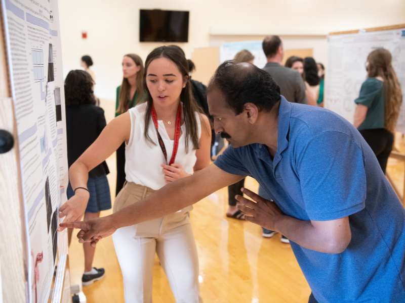 A student points out something on her poster