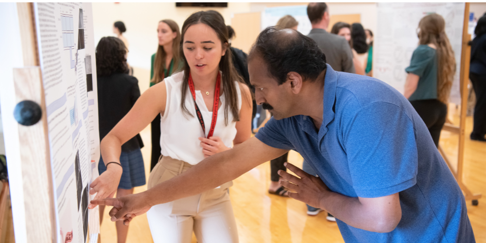 A student points out something on her poster