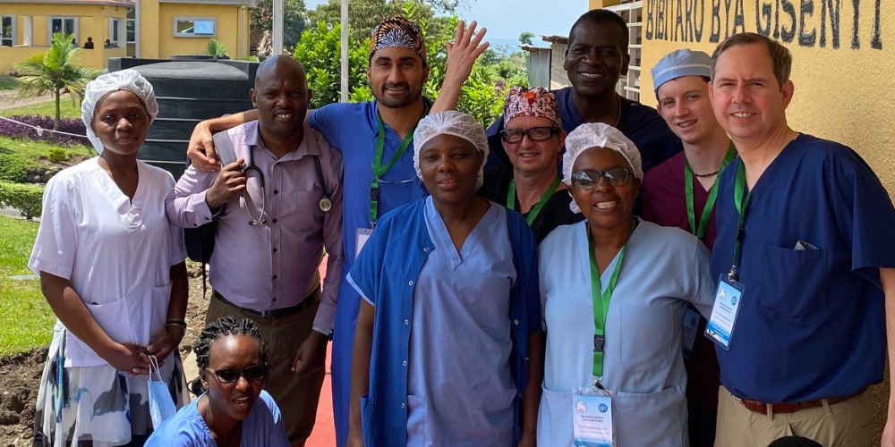 A group of medical professionals pose for a photo outside in Rwanda