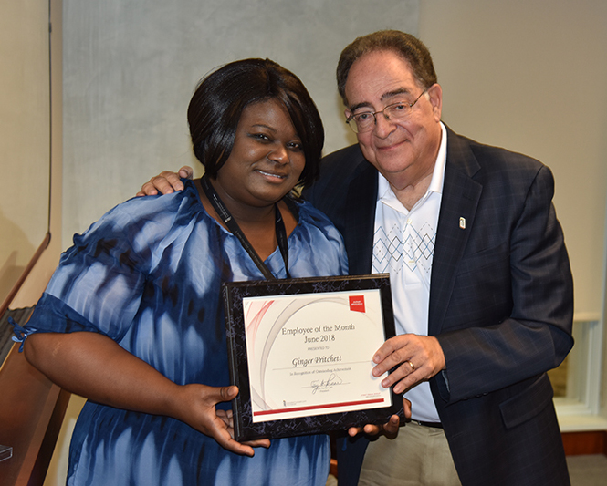 Employee of the Month Ginger Pritchett receiving her certificate from UMB's president