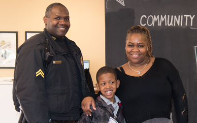 Cpl. Eugene Douglass, and Cpl. Hazel Lewis with a PAL participant from James McHenry Elementary/Middle School.