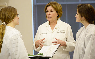 Claire M. Fraser, PhD, confers with collaborators in a lab. 
