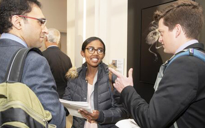 UM School of Pharmacy student Meron Assefa, center, speaks with team members Shaikh Afaq of the School of Medicine’s Public Health program, left, and Christopher Reed of UM Carey Law, right.