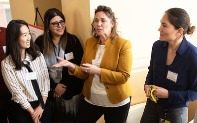 Diane Martin, PhD, director of the Geriatric and Gerontology Education and Research Program at UMB, gesturing, is among participants in the networking and ideas portion of the event launching the Age Friendly University collaboration between UMB and UMBC.