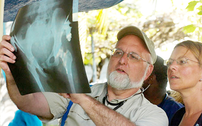 Robert R. Redfield, MD with coworker examining xray in the field