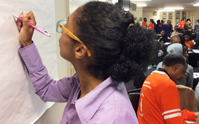 Amani Warren of the School of Social Work, community schools coordinator of Eutaw-Marshburn Elementary School, records ideas on how to prevent violence during a forum held Feb. 3, 2016.