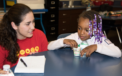 Anna Alikhani, a student at the University of Maryland School of Social Work and a trained health leader, talks to a student at Furman L. Templeton Preparatory Academy about the importance of eating healthy snacks.