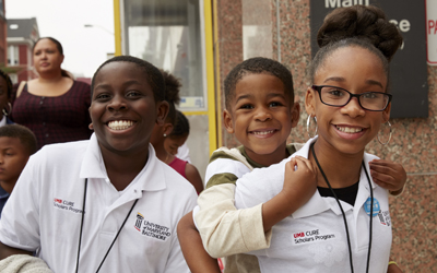 Jamiyah Mitchell, a sixth grader at Southwest Baltimore Charter School (right), her little brother (center), and Mouhamed Samb, also a sixth grader at Southwest Baltimore Charter School, tour the University of Maryland, Baltimore (UMB) campus after being inducted into the UMB CURE Scholars program at the White Coat Ceremony.