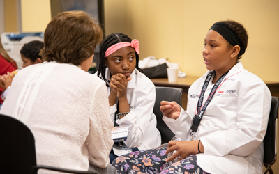 Rising seventh grade CURE Scholars, Kiersten Lockett (right) and Ka'mara Jenkins, talk to higher education presidents about their academic aspirations.