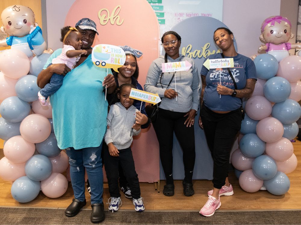 baby shower attendees posing with balloons