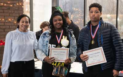 (From left) CURE executive director Gia Grier McGinnis, DrPH, MS, presents Mekayla Scott and Mekhi Taylor, both CURE Scholars in Cohort 1, with academic achievement awards.