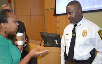 Image of Chief Williams speaking with a staff member at the town hall meeting.