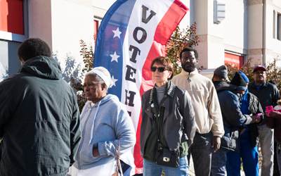 Voters lining up before the polls open on the first day of early voting at UMB's Community Engagement Center.