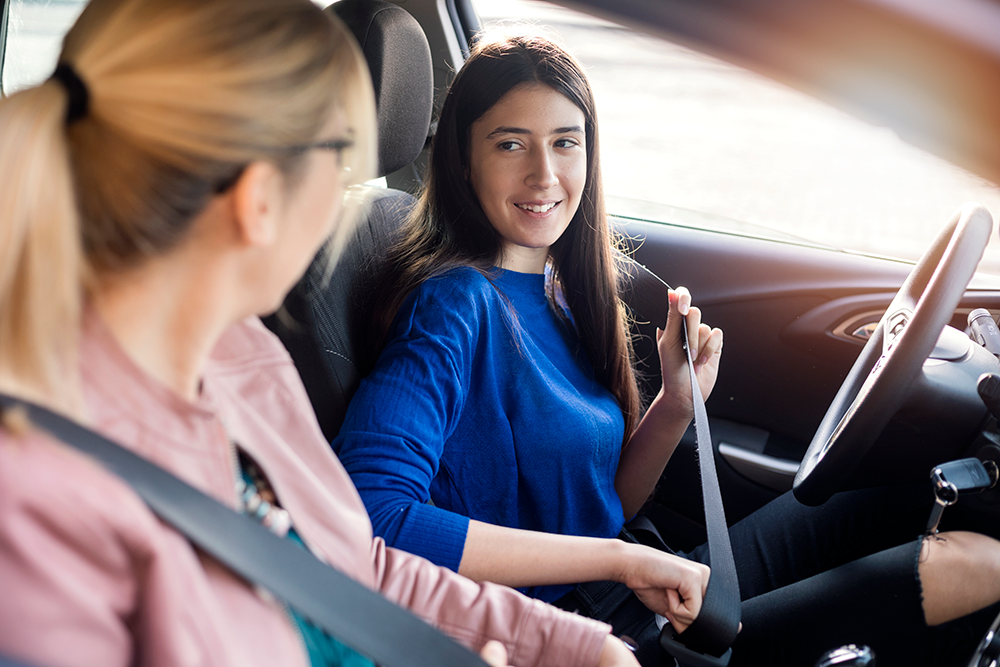young driver buckling up